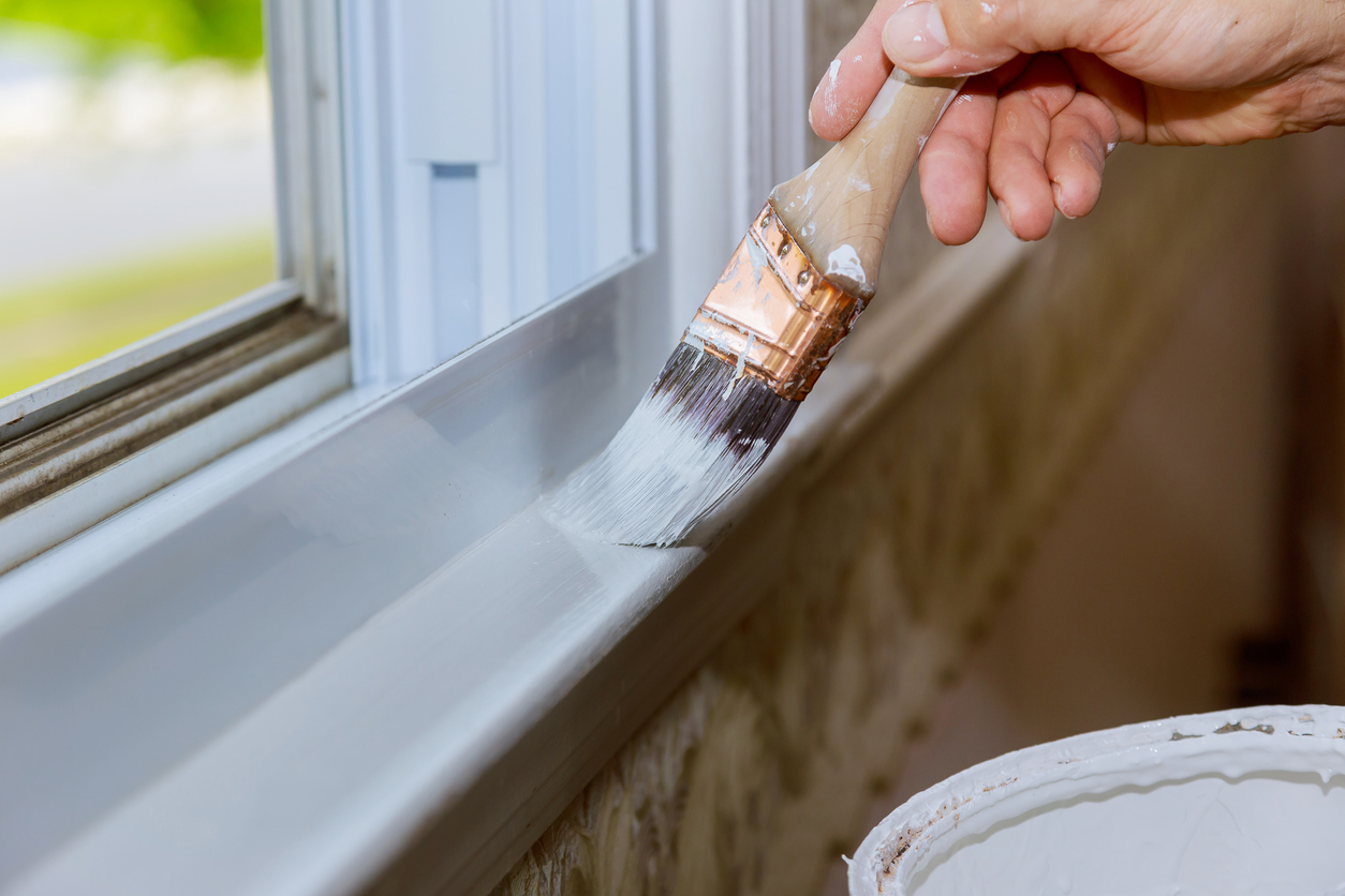 Close up of man hand carefully painting the edge of a window